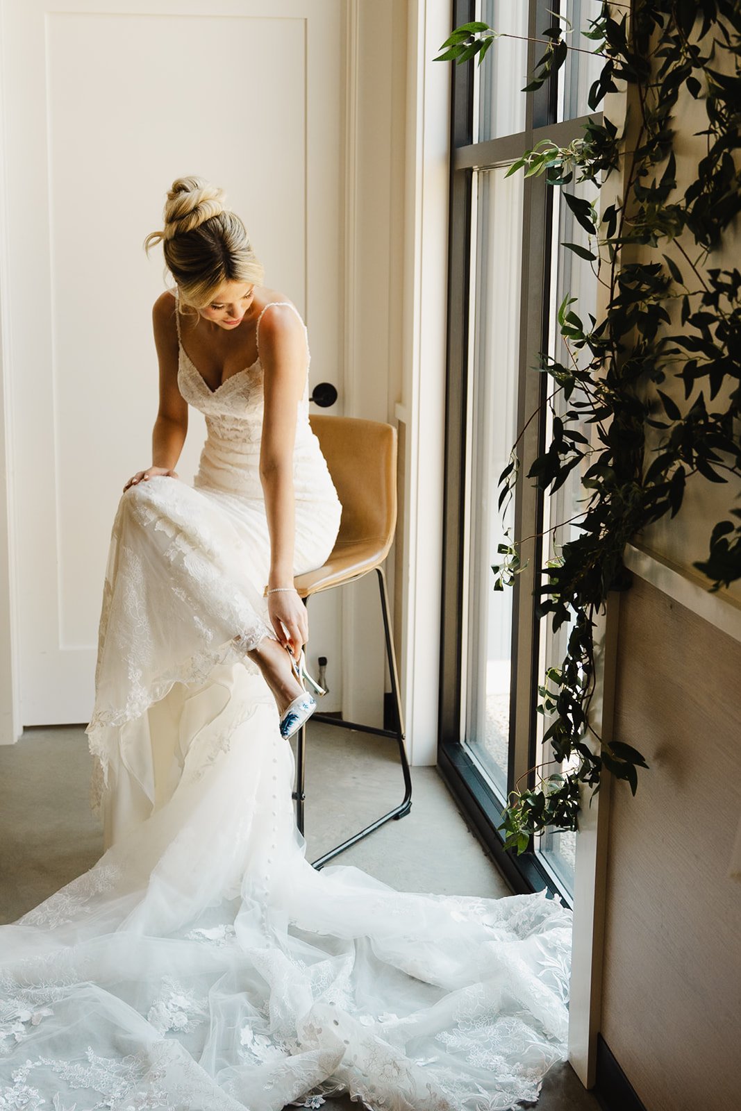 Bride in her wedding dress putting on heels during getting-ready moments at Retreat 21 near Columbus, Ohio