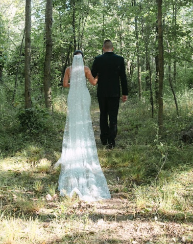 Bride and groom walking arm in arm into the woods at Retreat 21 near Columbus, Ohio