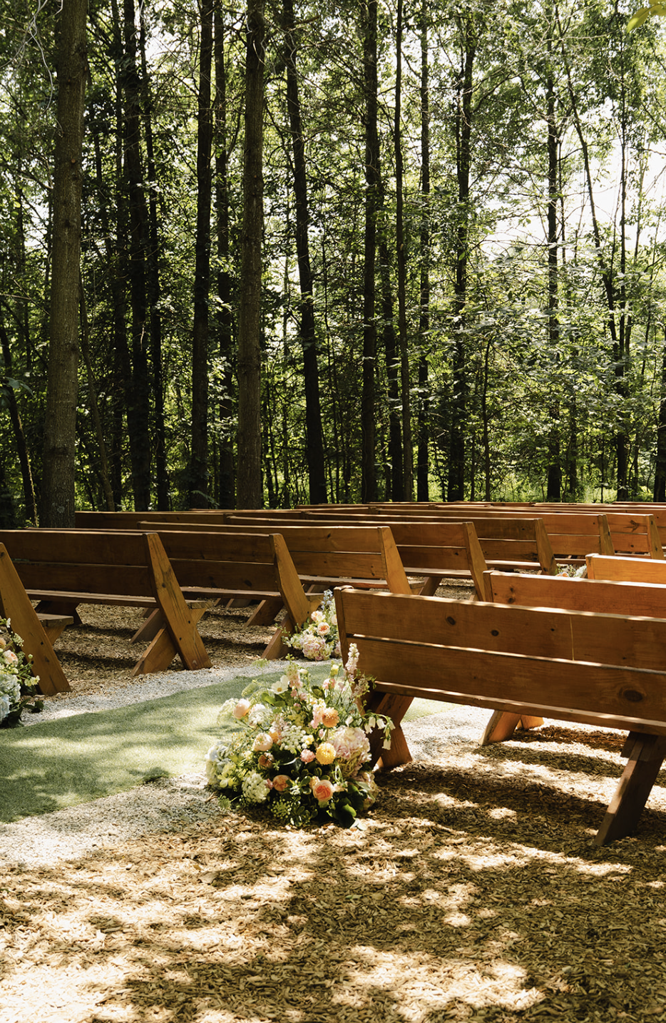 Outdoor wedding ceremony setup with wooden benches and forest backdrop at Retreat 21 near Columbus, Ohio