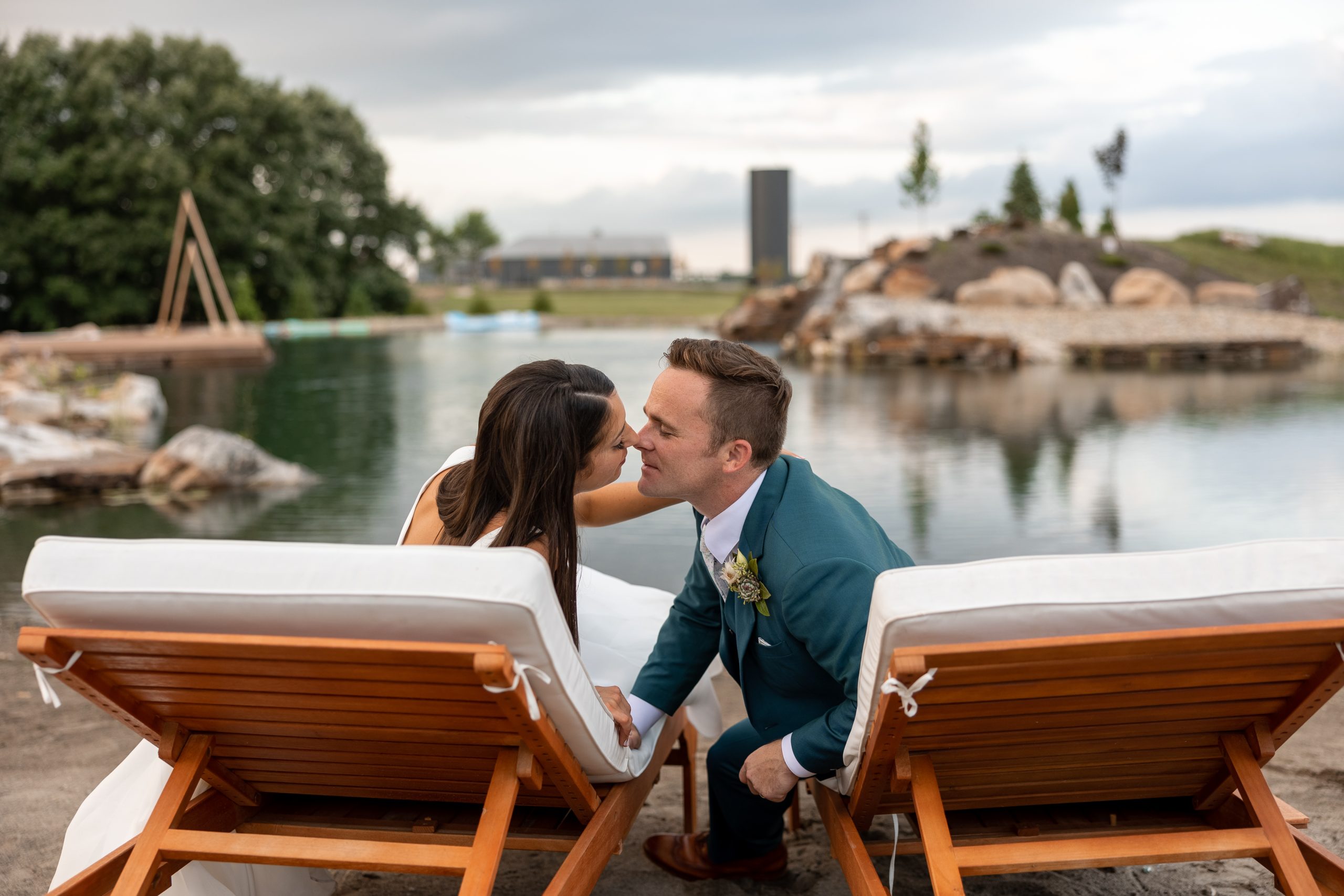 Bride and groom sitting in chairs outdoors near water feature at Retreat 21 near Columbus, Ohio