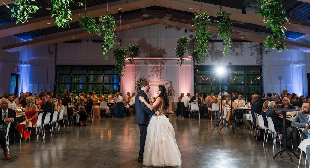 Bride and groom sharing their first dance as wedding party looks on at Retreat 21 near Columbus, Ohio