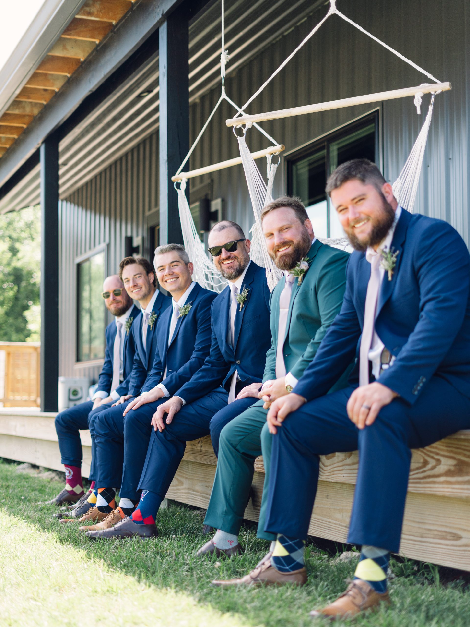 Groomsmen lined up outdoors smiling at the camera at Retreat 21 near Columbus, Ohio