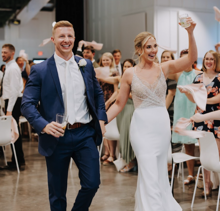 Bride and groom enter wedding reception as guests stand and clap at Retreat 21 near Columbus, Ohio