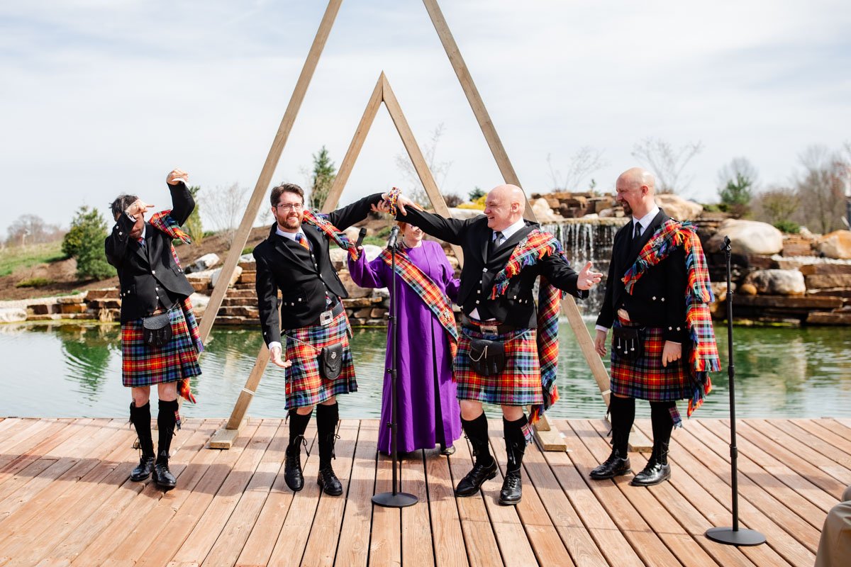 Groomsmen in Celtic wedding attire with water feature in the background at Retreat 21 near Columbus, Ohio