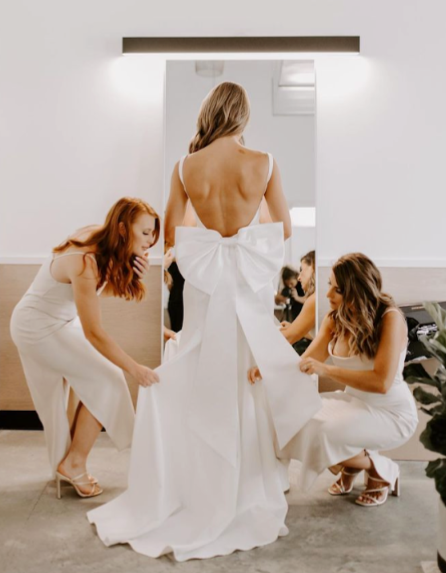 Bridesmaids helping bride in white dress during wedding preparation at Retreat 21 near Columbus, Ohio