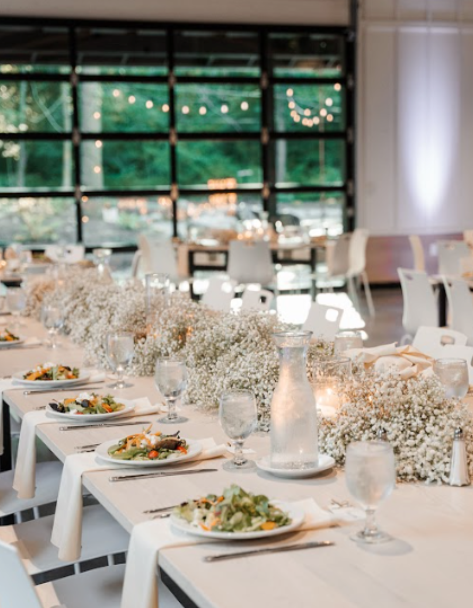 Candlelit dinner setup with white tables and elegant decor, no guests present, at Retreat 21 near Columbus, Ohio