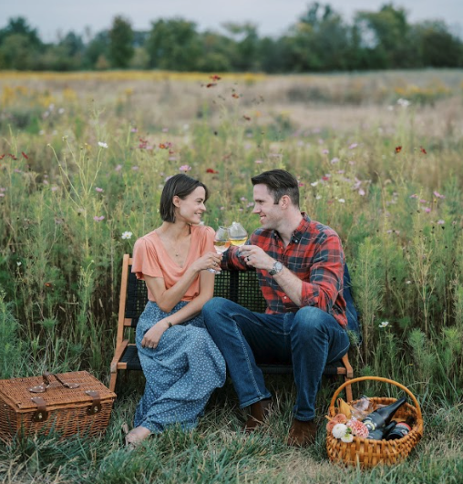 A couple enjoys shaded seating under the Pergolas at The Taphouse, near the bocce courts